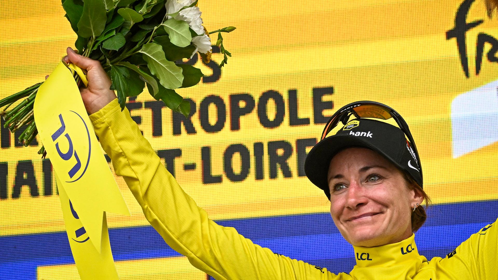 Marianne Vos hält in der rechten Hand einen Blumenstrauß und jubelt. Marianne Vos hält in der rechten Hand einen Blumenstrauß und jubelt.