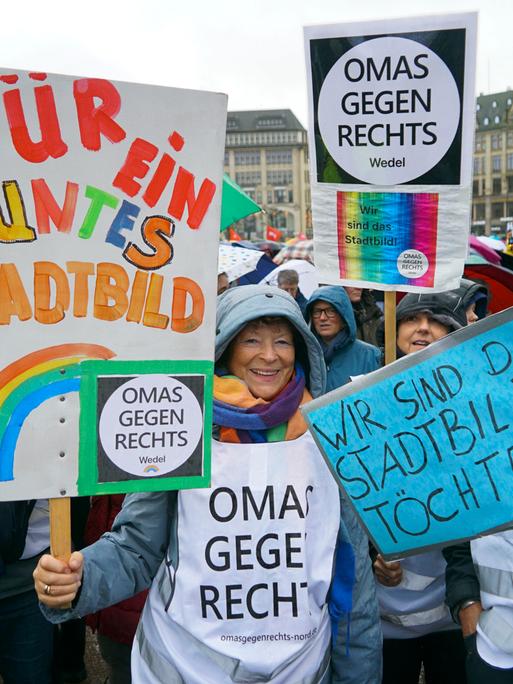 Mehrere Menschen stehen im Regen. Sie halten Plakate in die Höhe. Auf einem Plakat steht: "Für ein buntes Stadtbild" Mehrere Menschen stehen im Regen. Sie halten Plakate in die Höhe. Auf einem Plakat steht: "Für ein buntes Stadtbild"