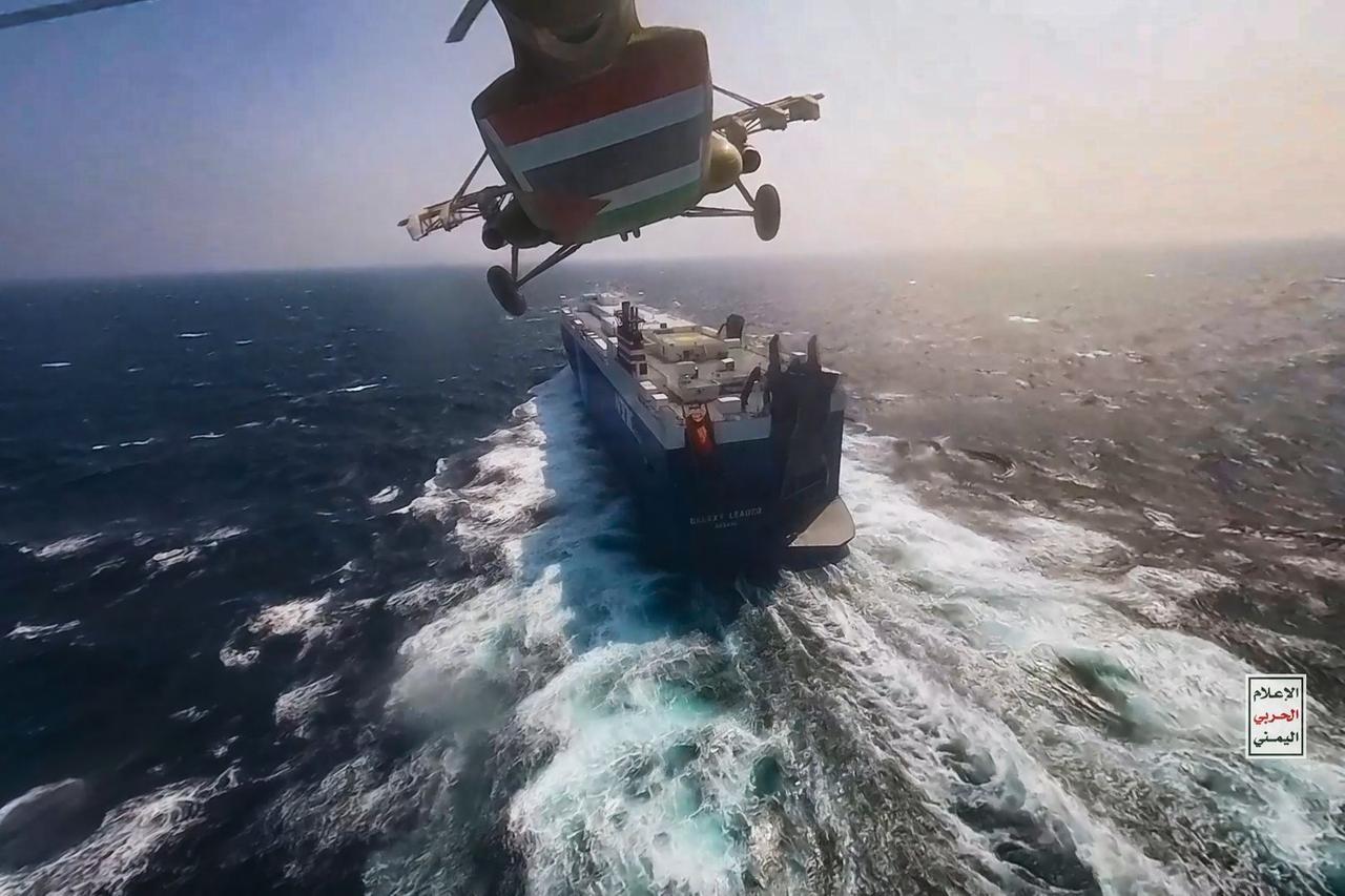 Der Hubschrauber fliegt gerade knapp hinter einem Frachtschiff hinterher und will landen.