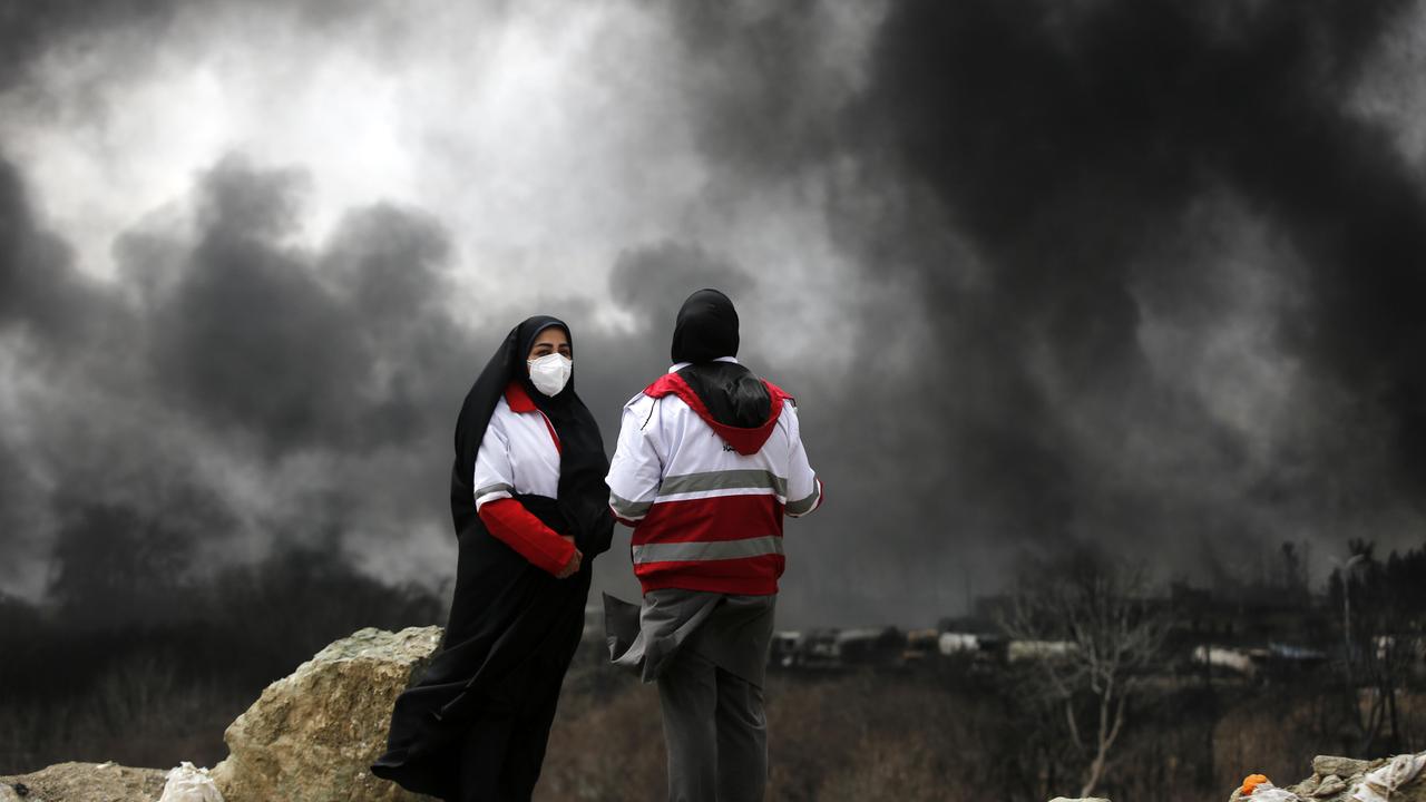 Zwei Personen stehen auf einer Annöhe und sehen schwarzer Rauch aufsteigen nach einem Angriff in Tehran. Zwei Personen stehen auf einer Annöhe und sehen schwarzer Rauch aufsteigen nach einem Angriff in Tehran.