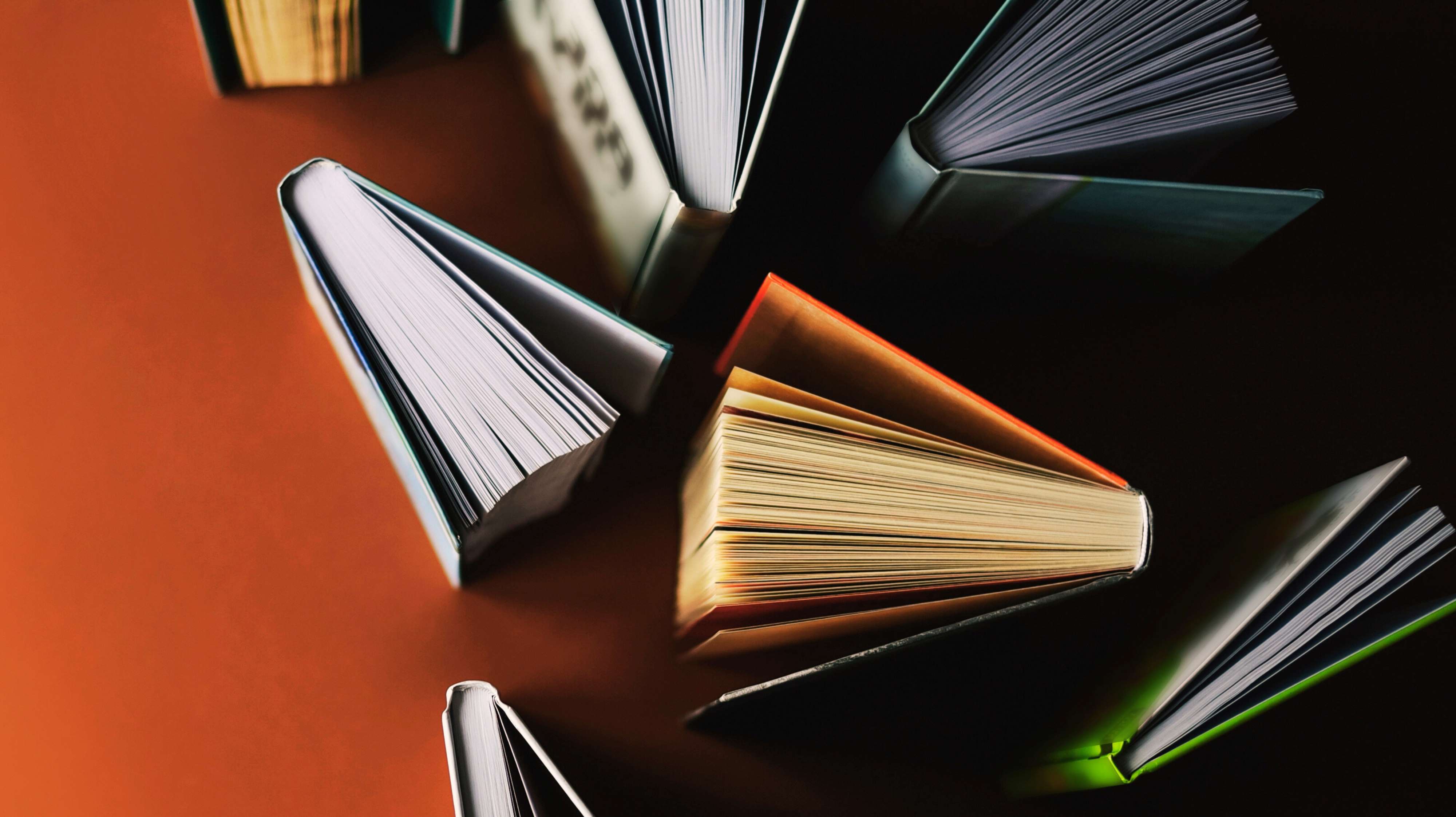 Durcheinander aufgestellte Bücher auf einem roten Tisch