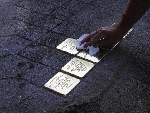 Verlegung und Putzen von Stolpersteinen zum Gedenken an die deportierten jüdischen Bewohner eines Hauses in Deutschland.