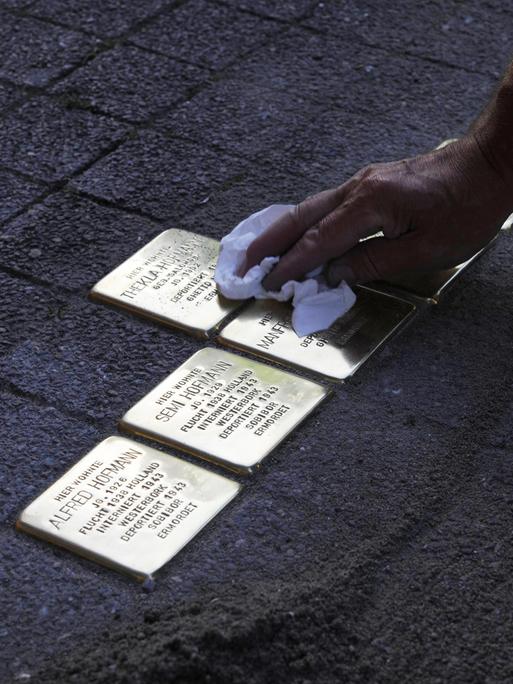 Verlegung und Putzen von Stolpersteinen zum Gedenken an die deportierten jüdischen Bewohner eines Hauses in Deutschland.