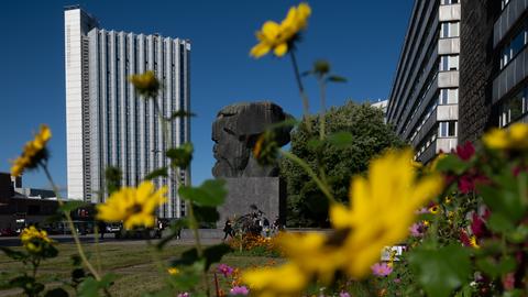 Bunte Blumen wachsen hinter dem Karl-Marx-Monument im Zentrum von Chemnitz. 
