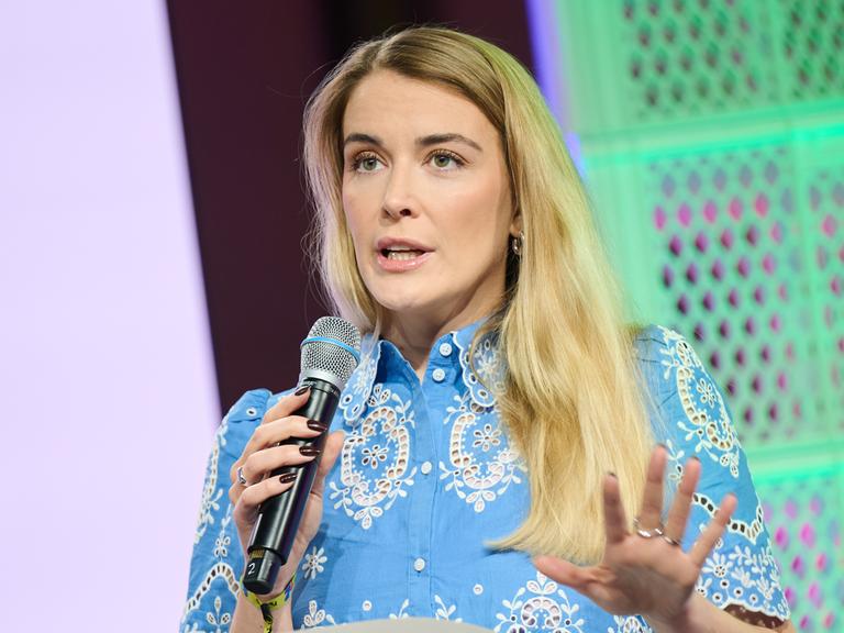 Annika Brockschmidt, Journalistin und Autorin, spricht während der Digitalmesse Republica in Berlin in ein Mikrofon und gestekuliert mit der linken Hand Annika Brockschmidt, Journalistin und Autorin, spricht während der Digitalmesse Republica in Berlin in ein Mikrofon und gestekuliert mit der linken Hand