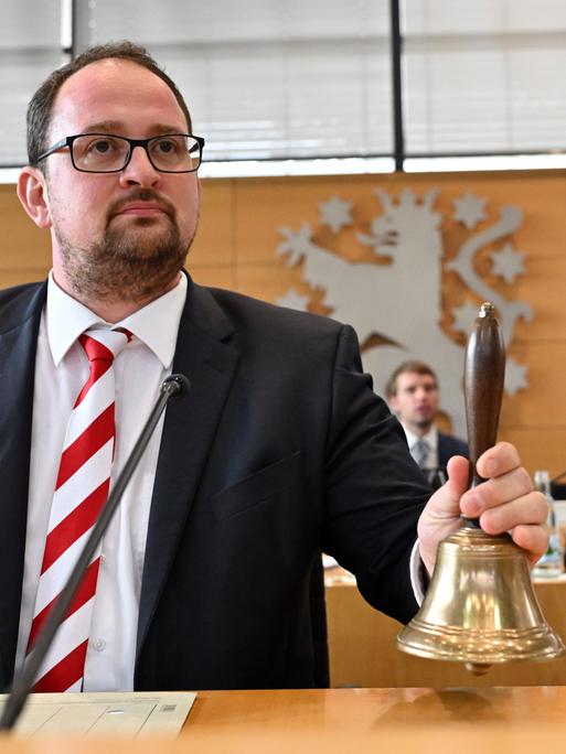 Thadäus König (CDU) ist neuer Landtagspräsident des Thüringer Landtags. Er sitzt im Landtag und läutet eine Glocke. (28.09.2024)