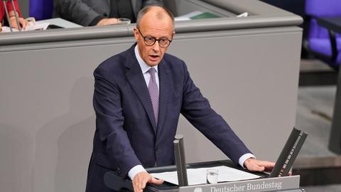 Bundeskanzler Merz steht im Bundestag hinter einem Rednerpult.