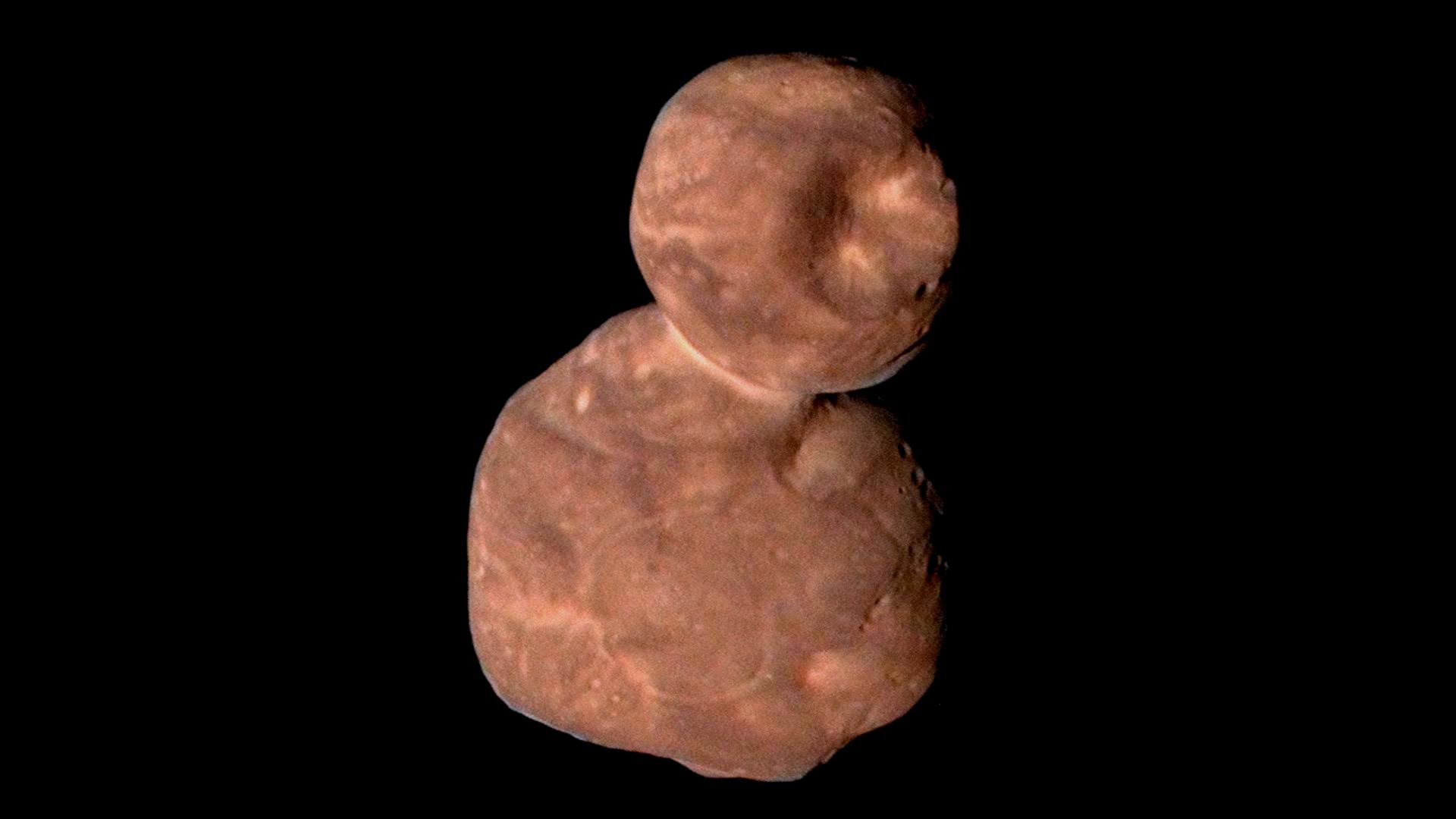 Ein rötliches Objekt, das einem Schneemann gleicht, ist vor schwarzem Hintergrund zu sehen.