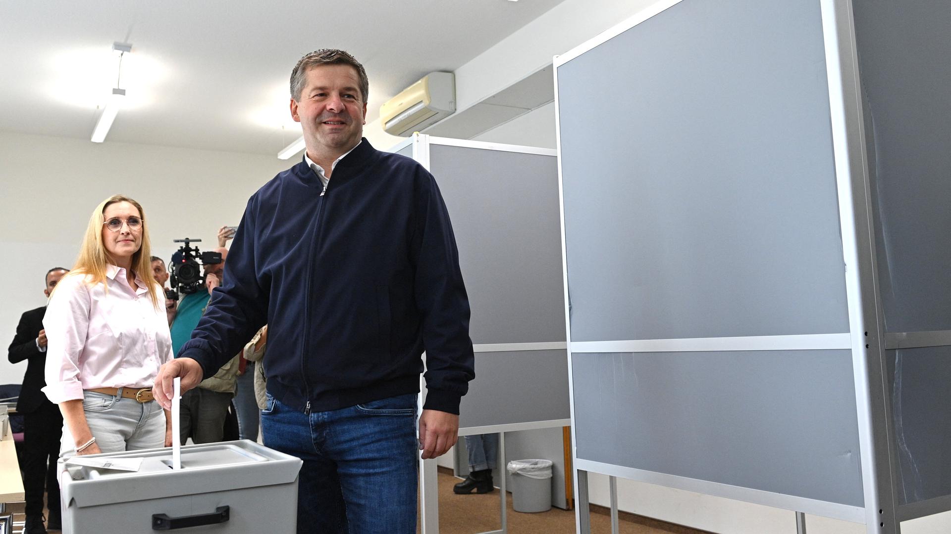 Sven Schulze (CDU), Ministerpräsident des Landes Sachsen-Anhalt und Landesvorsitzender der CDU, wirft seinen gefalteten Stimmzettel in die Wahlurne. Hinter ihm steht seine Ehefrau Kati Schulze. Sven Schulze (CDU), Ministerpräsident des Landes Sachsen-Anhalt und Landesvorsitzender der CDU, wirft seinen gefalteten Stimmzettel in die Wahlurne. Hinter ihm steht seine Ehefrau Kati Schulze.