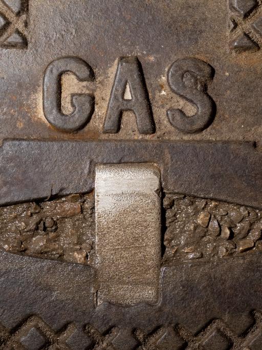 Der Schriftzug Gas steht in einem Wohngebiet auf einer gusseisernen Straßenkappe einer Gasleitung.