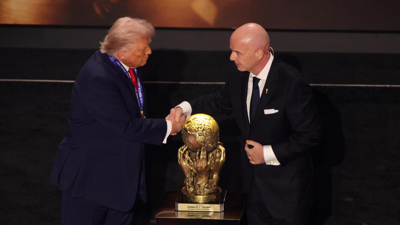 US-Präsident Donald Trump und FIFA-Präsident Gianni Infantino schütteln sich die Hände vor dem goldenen Pokal des FIFA-Friedenspreises für Trump.