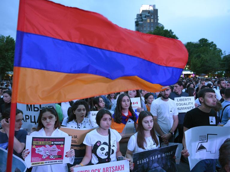 Viele Demonstrierende halten Plakate und die armenische Flagge, um gegen die aserbaidschanische Blockade von Bergkarabach zu demonstrieren.