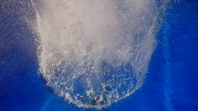 Wasser spritzt aus einem Schwimmbecken. 