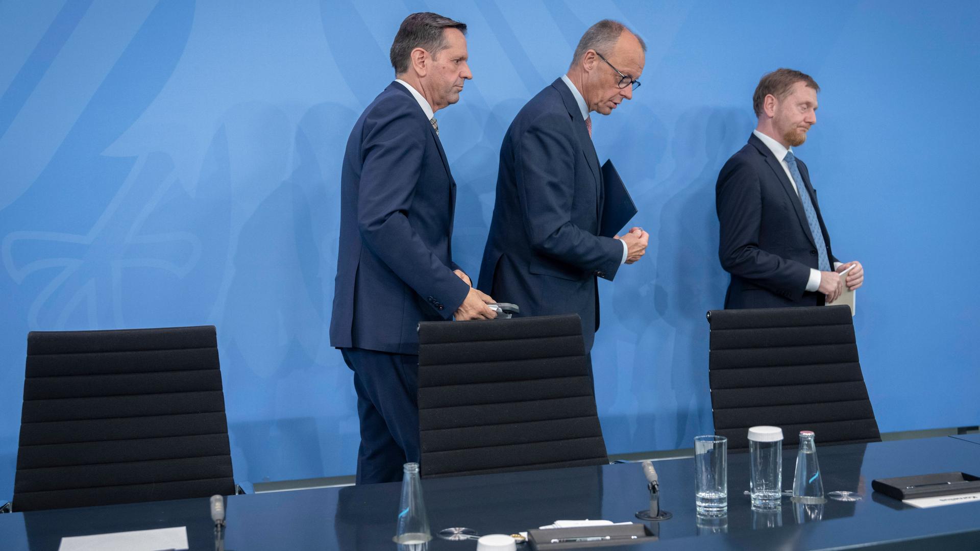 Olaf Lies (SPD), Ministerpräsident von Niedersachsen, Bundeskanzler Friedrich Merz (CDU) und Michael Kretschmer (CDU), Ministerpräsident Sachsen, verlassen das Podium nach ihrer Pressekonferenz zum Treffen der Länderchefs, Bundesministern und Kanzler.