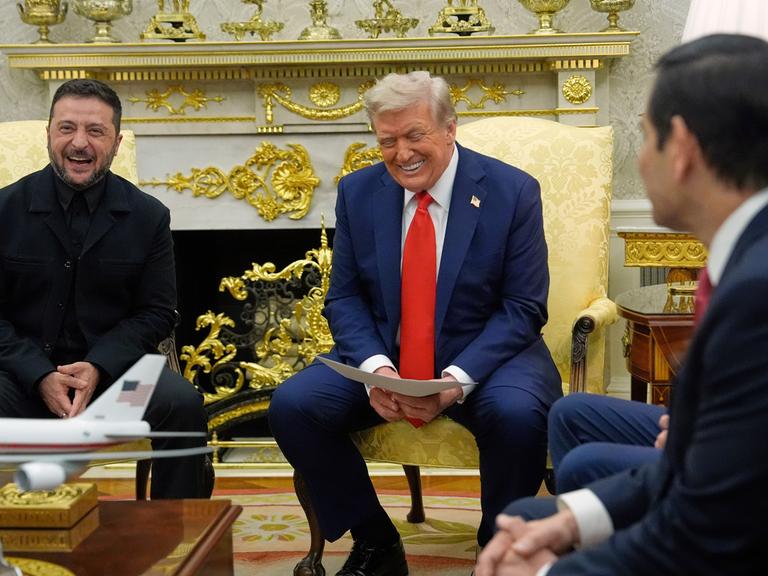 Donald Trump und Wolodymyr Selenskyj sitzen nebeneinander im Oval Office und lachen