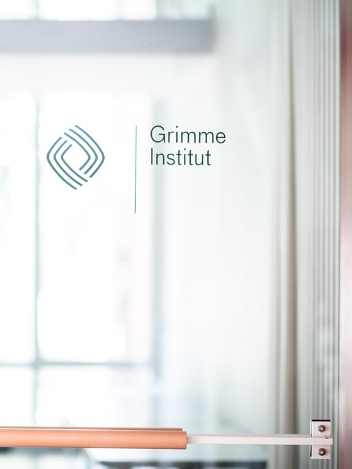 Grimme-Instituts-Chefin Frauke Gerlach neben einer Glastür mit Grimme-Aufschrift