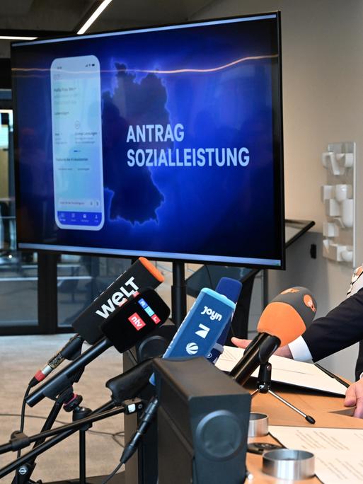 Bärbel Bas (r, SPD), Bundesministerin für Arbeit und Soziales, und Karsten Wildberger (CDU), Bundesminister für Digitalisierung und Staatsmodernisierung (BMDS), verfolgen gemeinsam mit BMDS-Sprecherin Betty Kieß (l) eine Videopräsentation.