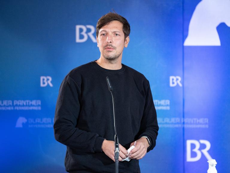 Der Reporter Thilo Mischke steht während der Verleihung des Bayerischen Fernsehpreises für seine ProSieben-Reportage "Deutsche an der ISIS-Front" vor einem blauen Hintergrund mit dem Logo des BR. Der Reporter Thilo Mischke steht während der Verleihung des Bayerischen Fernsehpreises für seine ProSieben-Reportage "Deutsche an der ISIS-Front" vor einem blauen Hintergrund mit dem Logo des BR.