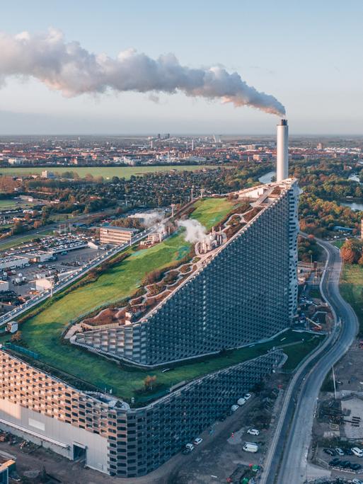 Vogelperspektive auf ein großes Kraftwerk mit einer Skipiste auf dem Dach.