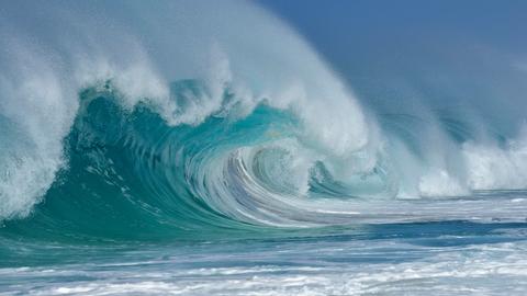 Auf dem Ozean bricht sich eine große Welle. 