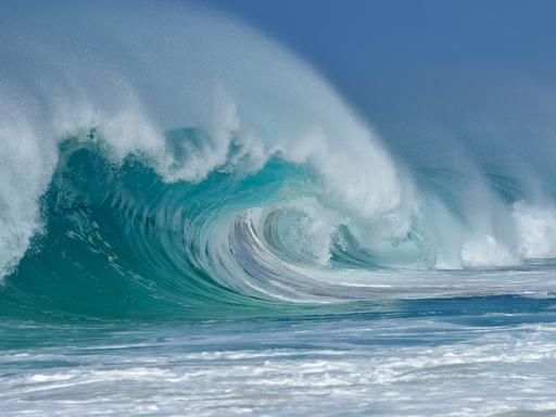 Auf dem Ozean bricht sich eine große Welle. 