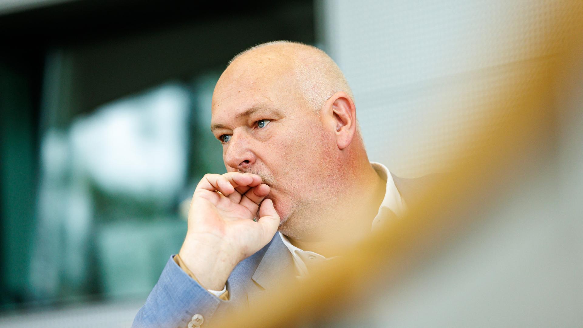 Der sächsische AfD-Politiker Jörg Dornau hält eine Hand vor den Mund und schaut nachdenklich.