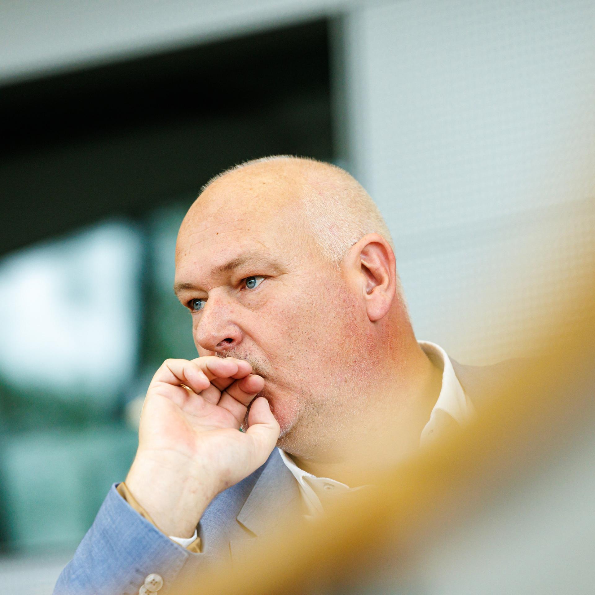 Der sächsische AfD-Politiker Jörg Dornau hält eine Hand vor den Mund und schaut nachdenklich.