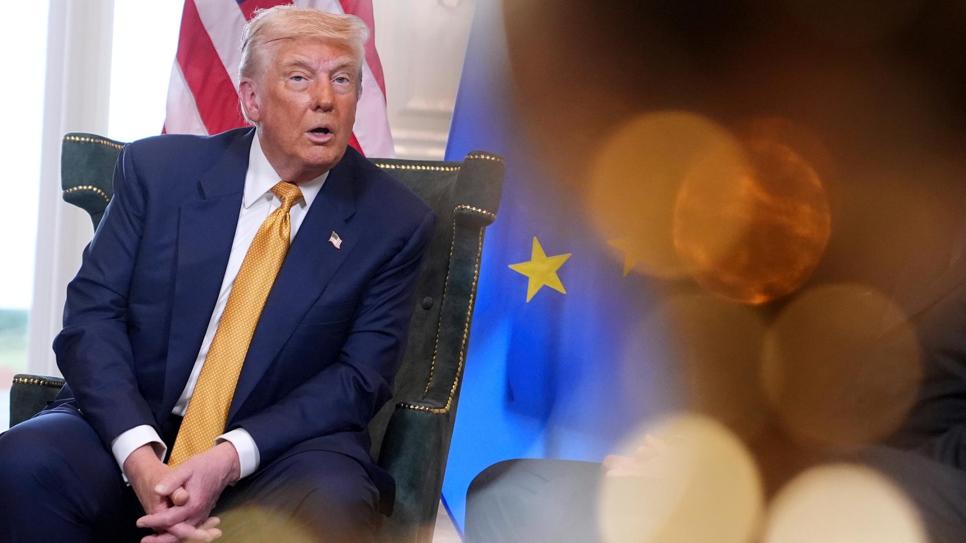 US-Präsident Donald Trump neben einer EU-Fahne. 