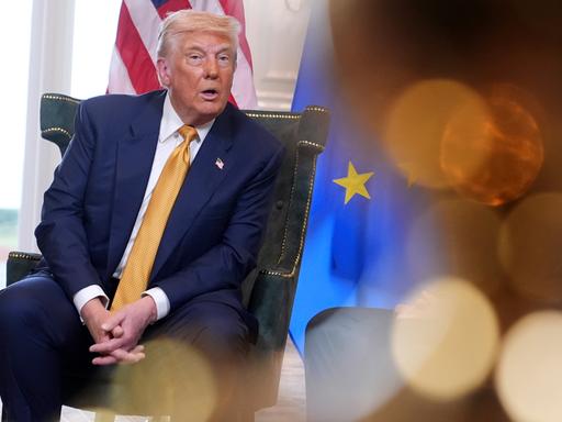 US-Präsident Donald Trump neben einer EU-Fahne. 