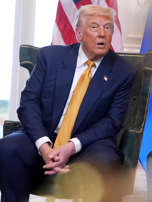 US-Präsident Donald Trump neben einer EU-Fahne. 