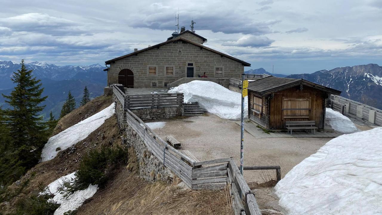 Blick auf das Gebäude aus Steinen mit einem Vorhof, der von einem Lattenzaun begrenzt ist. Es sind mehrere Schneewehen zu sehen. Blick auf das Gebäude aus Steinen mit einem Vorhof, der von einem Lattenzaun begrenzt ist. Es sind mehrere Schneewehen zu sehen.