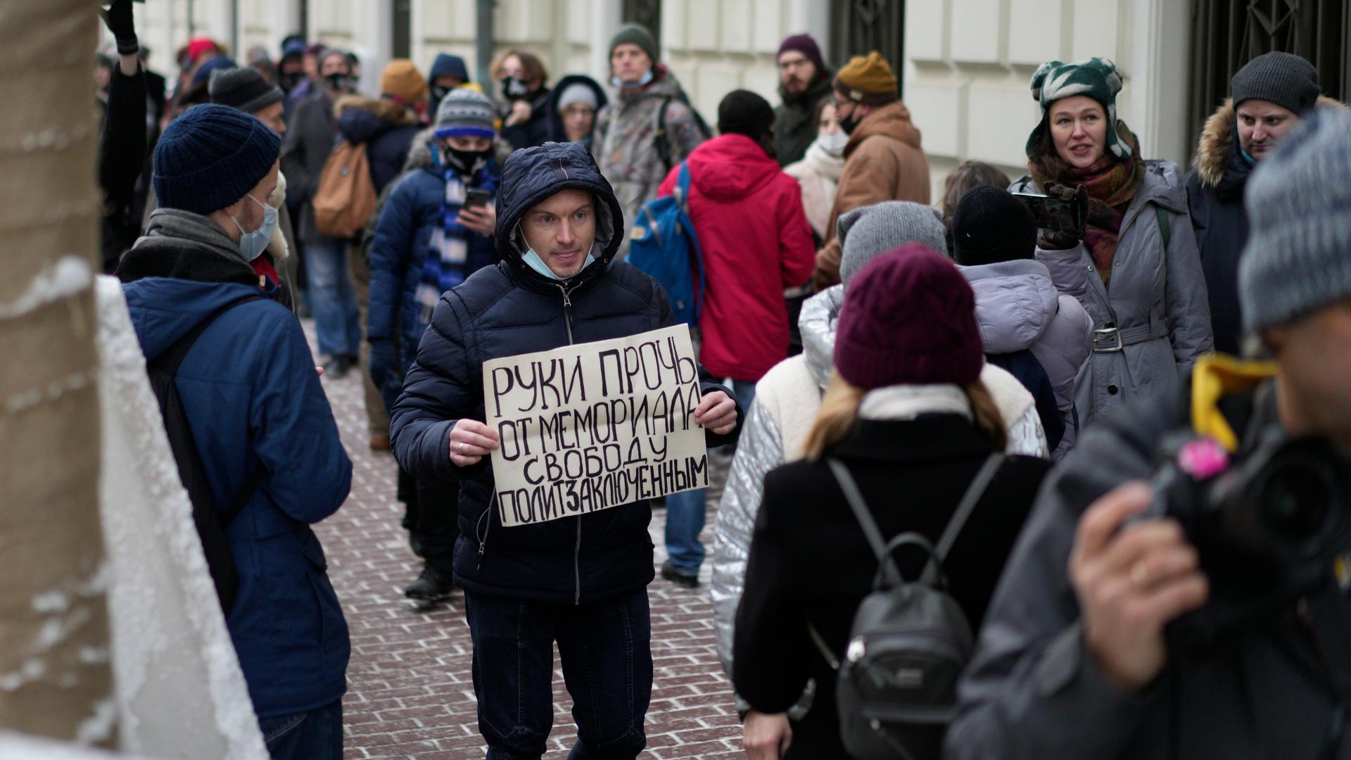Ein Demonstrant hält ein Plakat mit der Aufschrift "Hände weg von Memorial, Freiheit für politische Gefangene", während sich Menschen vor dem Obersten Gerichtshof der Russischen Föderation versammeln. Foto: Pavel Golovkin / dpa