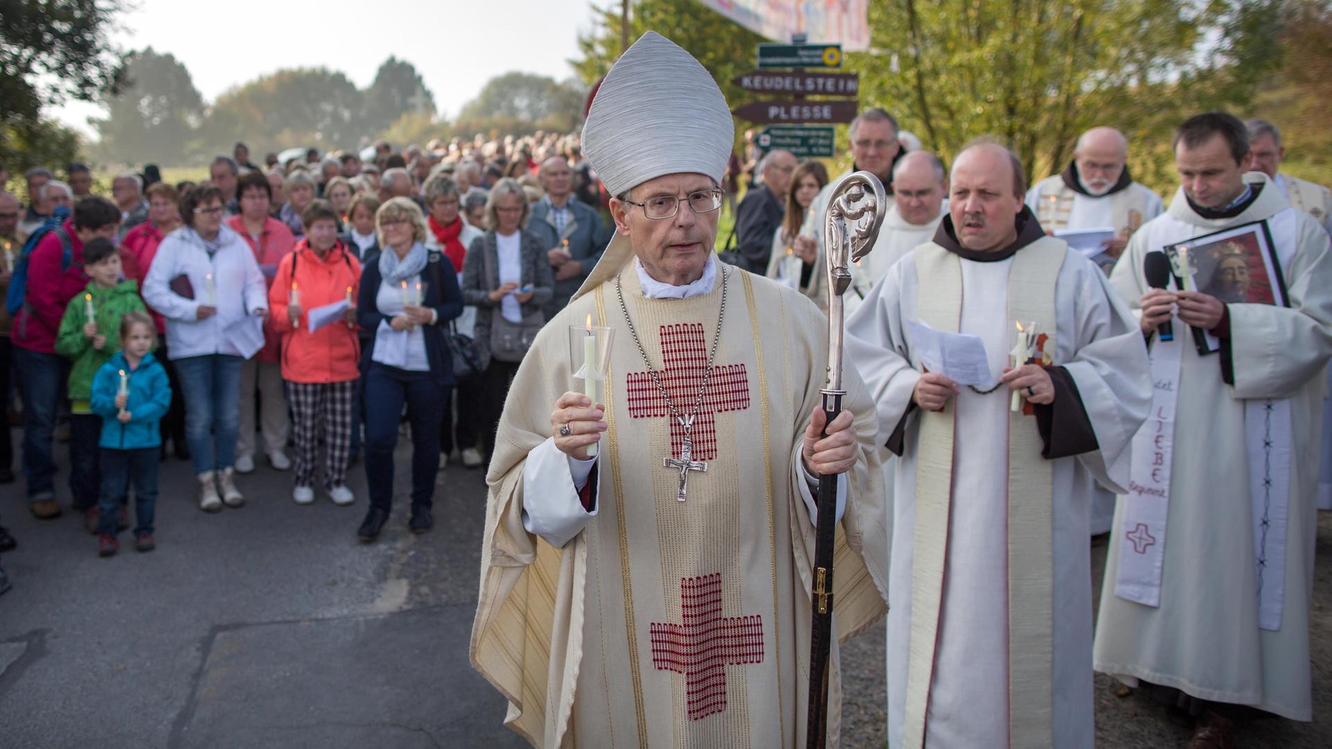 Wanke im hellen Ornat und mit weißer Bischofsmütze führt eine große Menschenmenge an. 