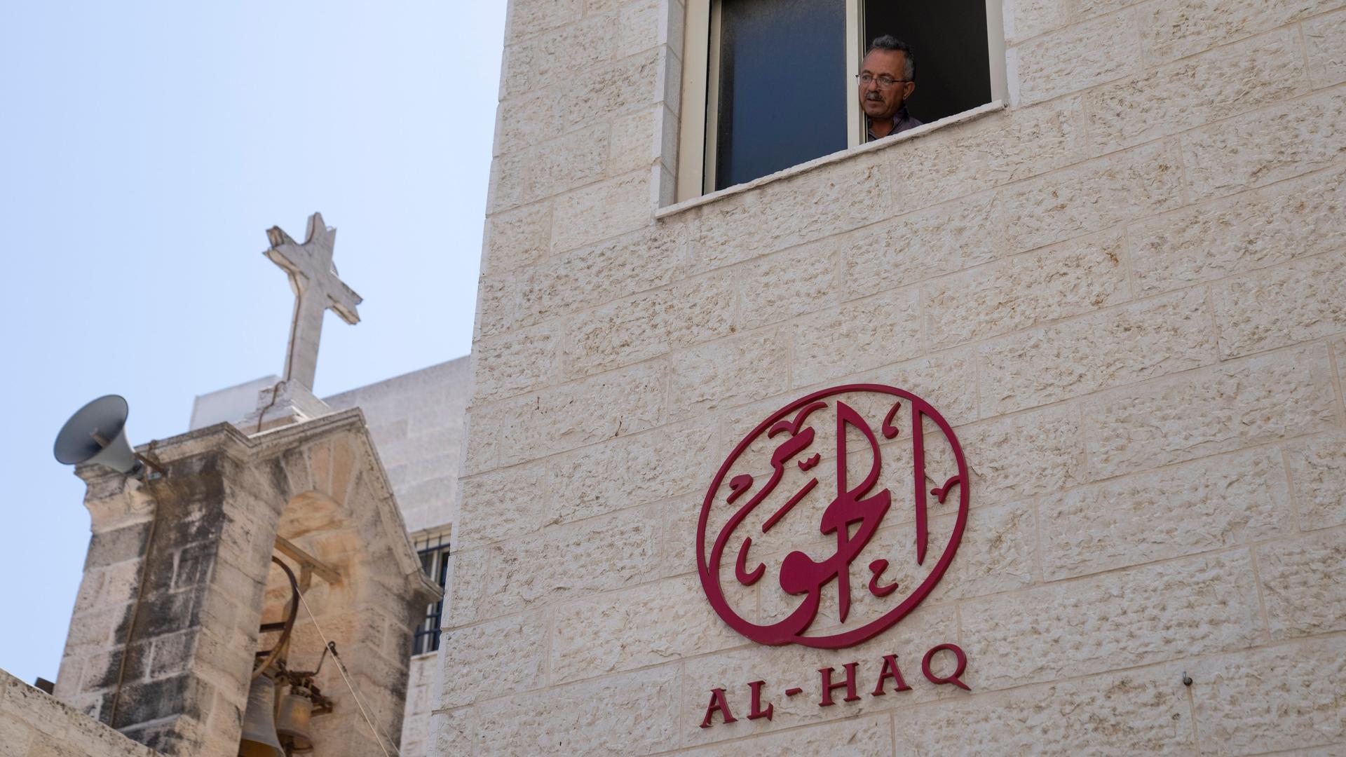 Ein Mann schaut aus einem Fenster des Büros der Menschenrechtsorganisation al-Hak in Ramallah. Im Hintergrund sieht man ein Kirche. Ein Mann schaut aus einem Fenster des Büros der Menschenrechtsorganisation al-Hak in Ramallah. Im Hintergrund sieht man ein Kirche.