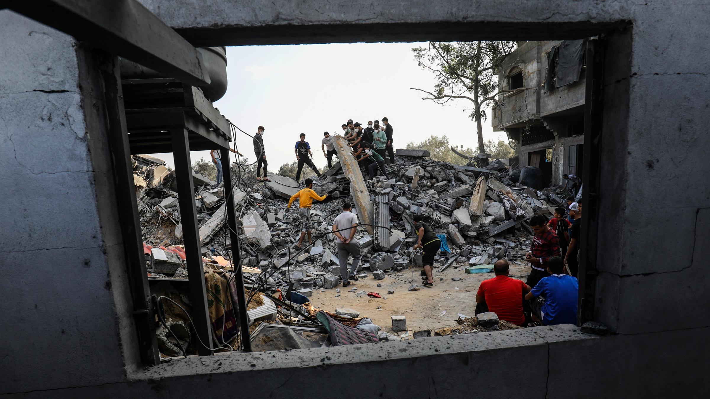 Zivilschutzteams und Anwohner starten eine Such- und Rettungsaktion rund um ein Haus das nach israelischen Angriffen auf den Gazastreifen zerstört wurde. 