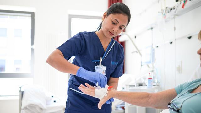 Die indische Pflegekraft Priyaraj Prabha legt einer Patientin eine Infusion.