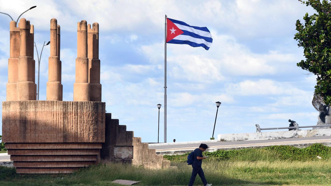 Ein Mann geht an einer Kubanischen Nationalflagge in Havanna vorbei.