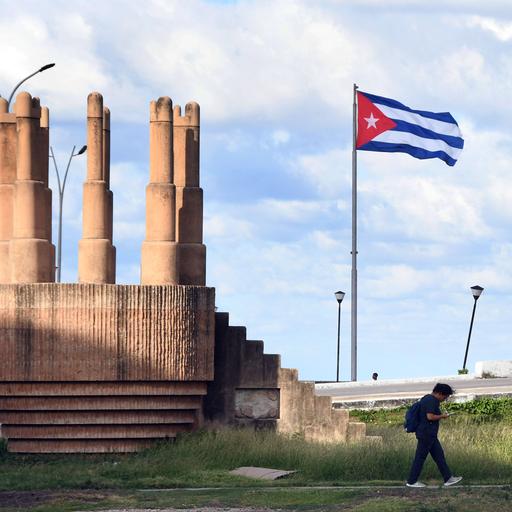Ein Mann geht an einer Kubanischen Nationalflagge in Havanna vorbei.