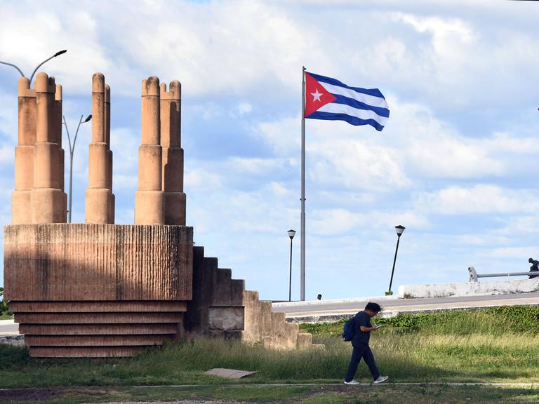 Ein Mann geht an einer Kubanischen Nationalflagge in Havanna vorbei.