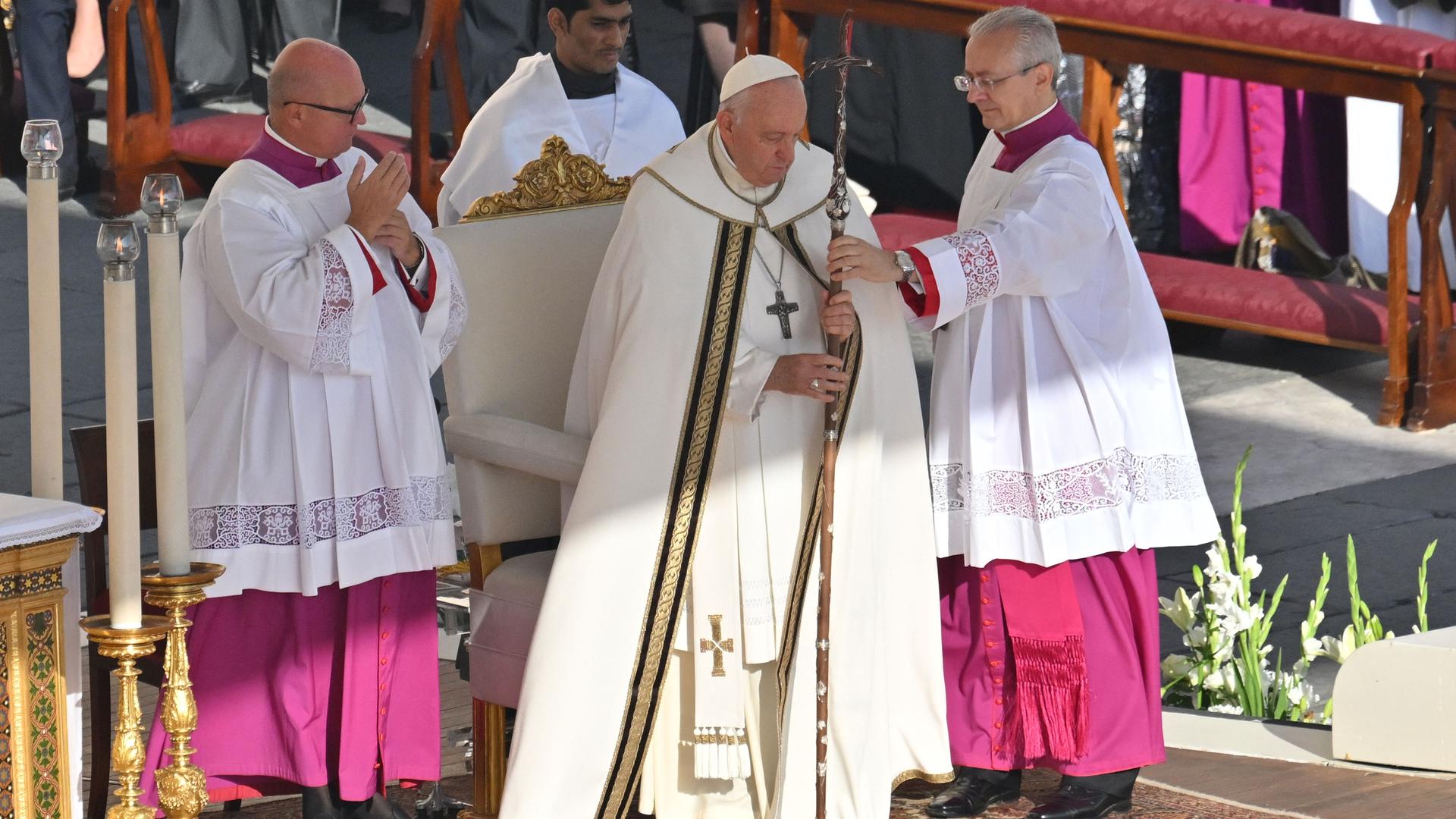 Papst Franziskus leitet die Messe der Weltsynode in Rom. Er steht mit einem großen Kreuz auf der Bühne.