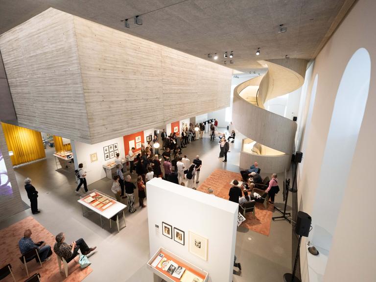Innenansicht des Archivs der Avantgarden - Egidio Marzona (ADA), zu sehen ein multifunktionaler Raum mit einem scheinbar schwebenden Betonkubus, der eine Forschungsplattform sowie Platz für Ausstellungen bietet.