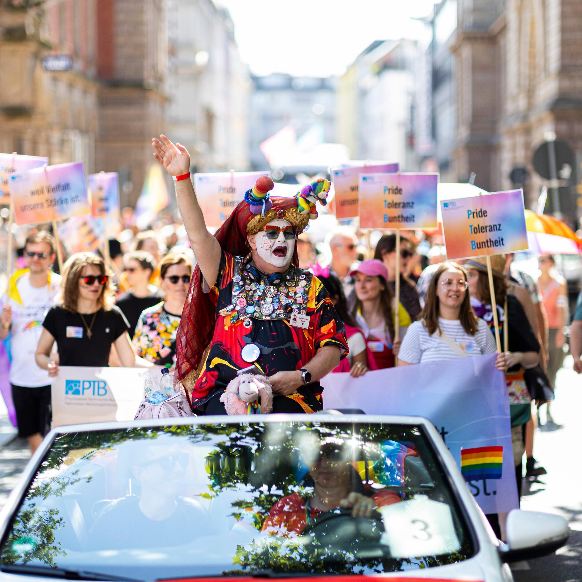 Teilnehmer vom Christopher Street Day (CSD) ziehen mit Schildern und Fahnen durch die Innenstadt von Braunschweig.