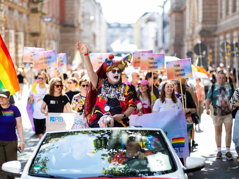 Teilnehmer des Christopher Street Days (CSD) ziehen mit Schildern und Fahnen durch die Innenstadt von Braunschweig.