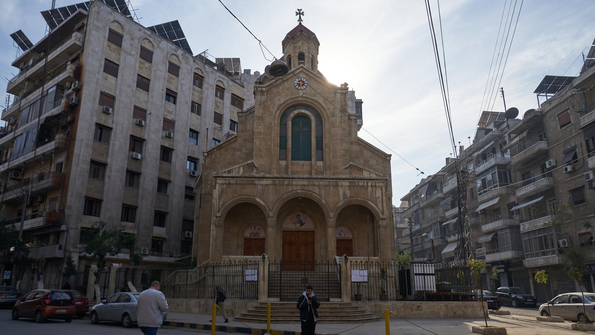 Bewohner laufen am 1. Dezember 2024 in Aleppo, Syrien, an einer Kirche vorbei, kurz zuvor hatte die bewaffnete Opposition die Stadt übernommen. (Foto: Karam Almasri/NurPhoto)