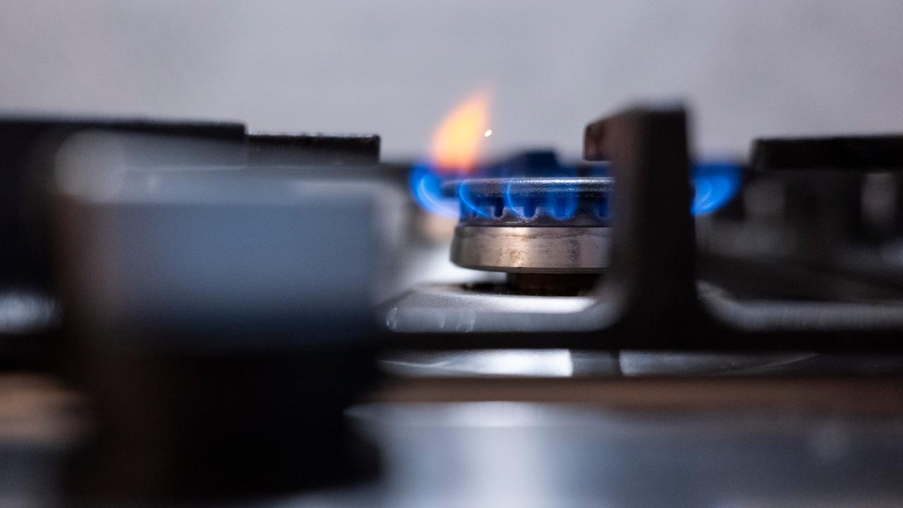 Eine Flamme ist an einem Gasherd in einer Küche zu sehen. 