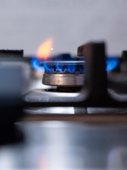 Eine Flamme ist an einem Gasherd in einer Küche zu sehen. 