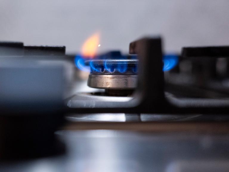 Eine Flamme ist an einem Gasherd in einer Küche zu sehen. 