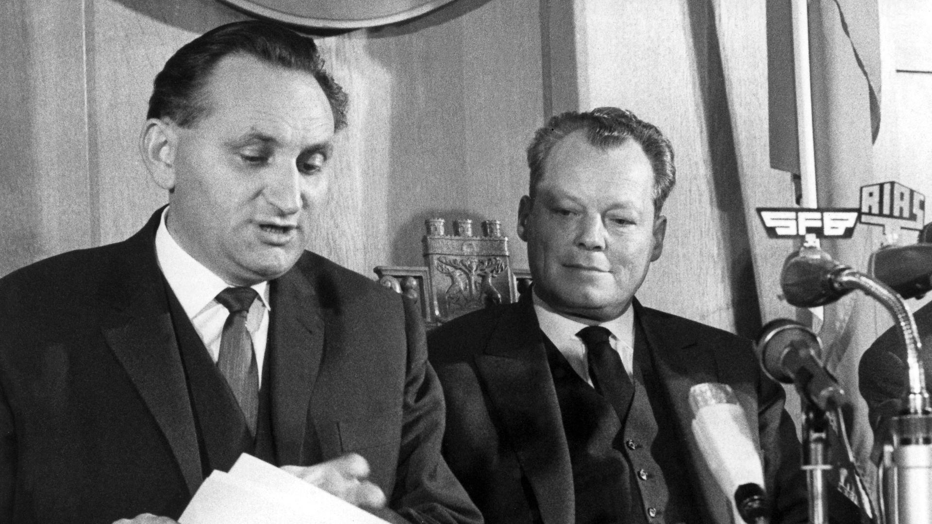 Der Regierende Bürgermeister von Berlin, Willy Brandt, und Senatspressechef Egon Bahr erläutern am 17.12.1963 auf einer Pressekonferenz im Rathaus Schöneberg die mit Vertretern der Sowjetzone getroffene Regelung in der Passierscheinfrage. 