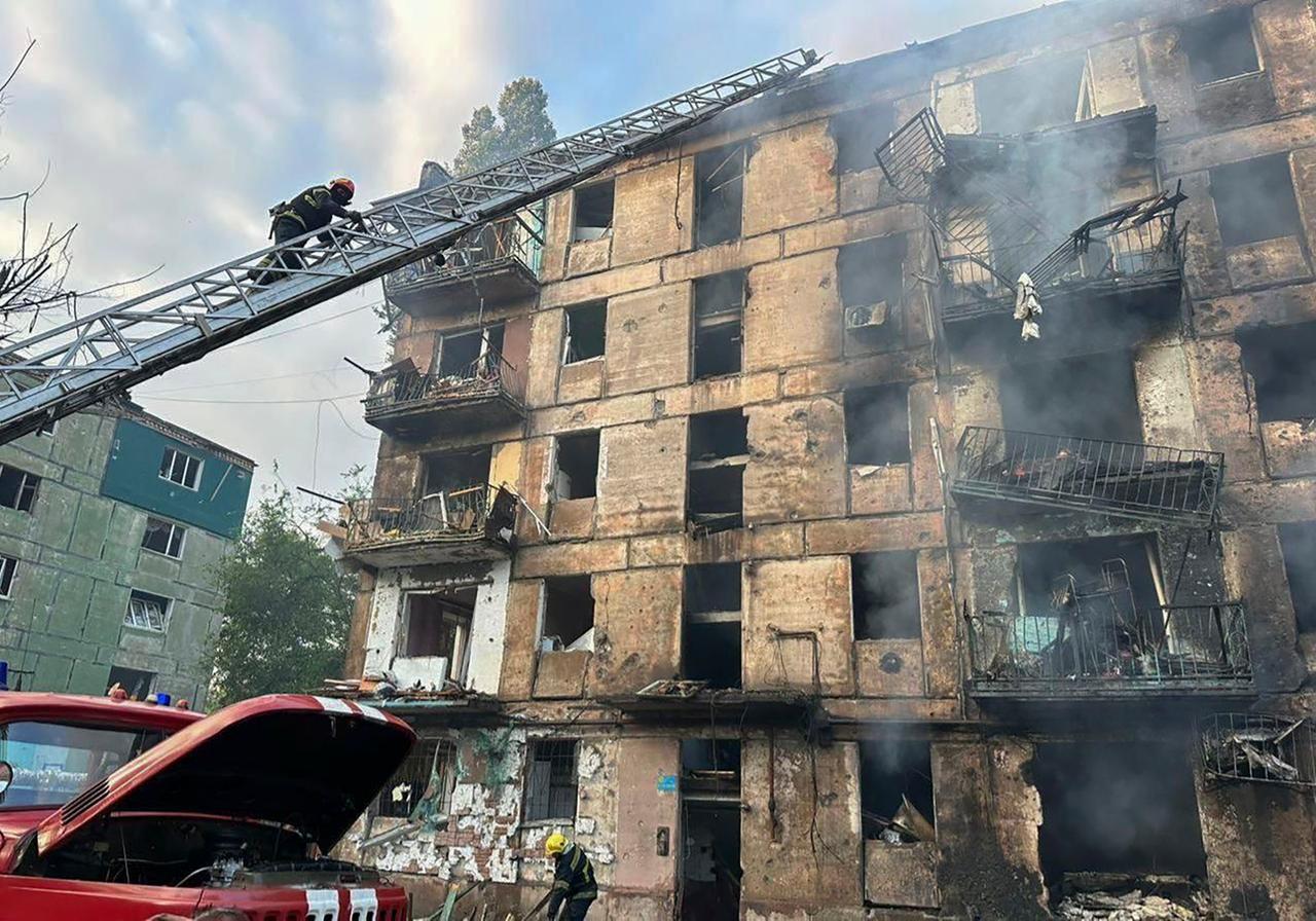 Ein Feuerwehrmann versucht, auf einer langen Leiter an ein stark zerstörtes Haus in Kryvyi-Rih in der Ukraine zu kommen.
