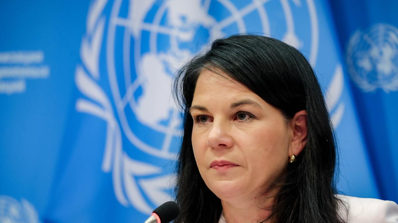 Annalena Baerbock, Präsidentin der 80. UN-Generalversammlung, sitzt vor einem Mikrofon. Im Hintergrund hängt die Flagge der Vereinten Nationen.